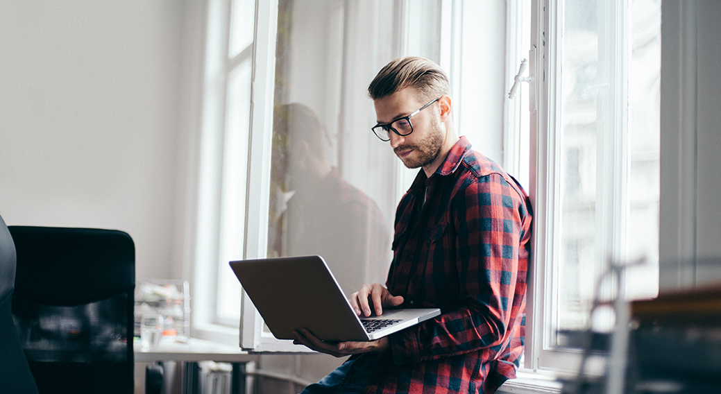 man-sitting-in-window-with-laptop